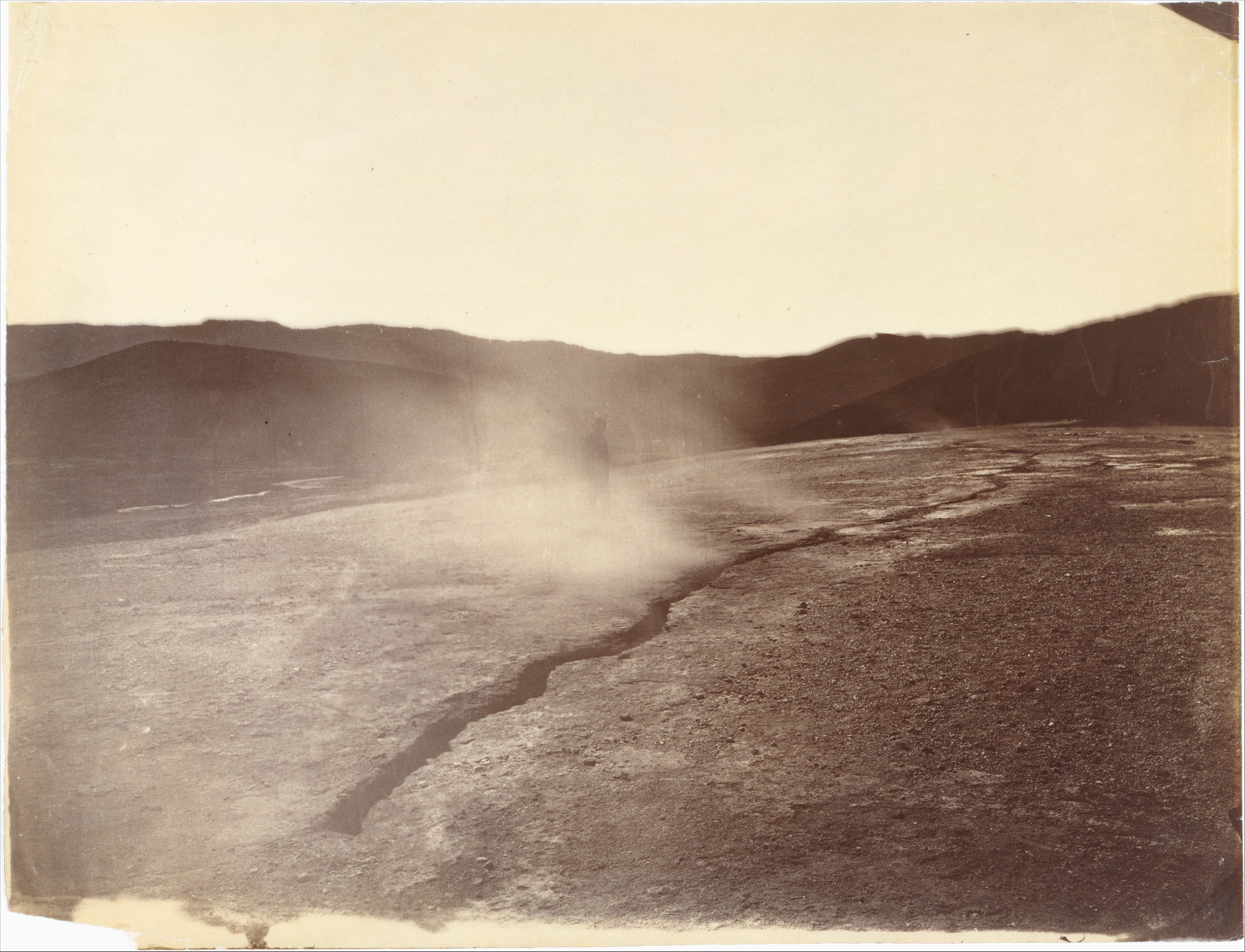 Steam rising from a geothermal fissure across open hills at Steamboat Springs, Nevada